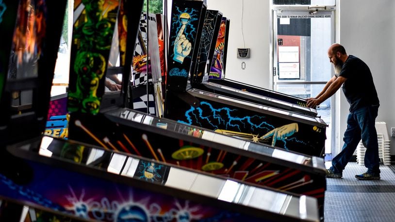Pinball Garage owner Brad Baker plays the brand new Teenage Mutant Ninja Turtles pinball game Thursday, June 25, 2020. Pinball Garage is now open in downtown Hamilton and offers a large selection of pinball machines to play along with a bar with rotating beer selection. NICK GRAHAM / STAFF