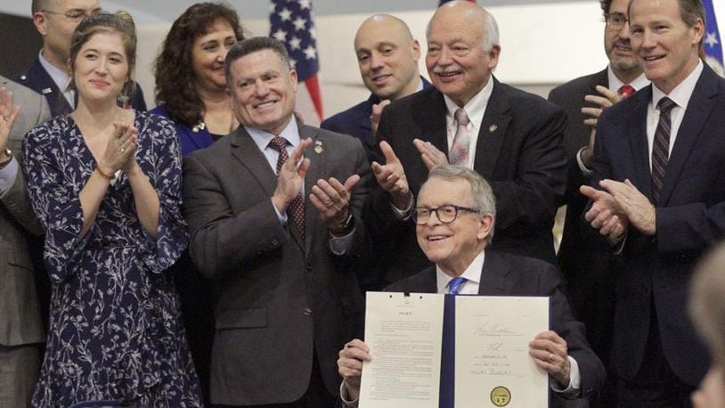 Gov. Mike DeWine signed Ohio Senate Bill 7 in January during a ceremony at the National Museum of the U.S. Air Force. From left to right are Brianna McKinnon, a military spouse and special education teacher, Rep. Rick Perales, Sen. Bob Hackett and Lt. Gov. Jon Husted. LISA POWELL / STAFF