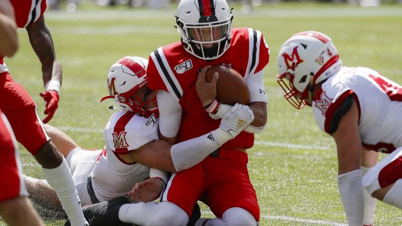 Cincinnati quarterback Desmond Ridder, center, is tackled on the run by Miami of Ohio defensive back Sterling Weatherford, center left, in the first half of an NCAA college football game, Saturday, Sept. 14, 2019, in Cincinnati. (AP Photo/John Minchillo)
