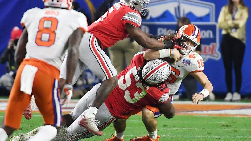 GLENDALE, ARIZONA - DECEMBER 28: Trevor Lawrence #16 of the Clemson Tigers is hit by Baron Browning #5 and Davon Hamilton #53 of the Ohio State Buckeyes in the second half during the College Football Playoff Semifinal at the PlayStation Fiesta Bowl at State Farm Stadium on December 28, 2019 in Glendale, Arizona. (Photo by Norm Hall/Getty Images)