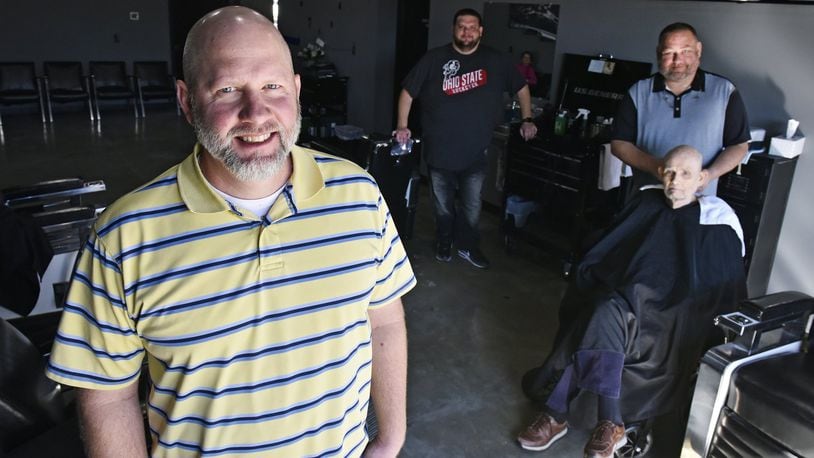 Owner Ryan Haynes, left, stands inside the Hamilton West Barber Shop with barbers Scott Page, middle, and Joe Templeton, cutting Tom Bellâ€™s hair, on the first day in the new location Monday, Oct. 28, 2019. Steve Mallicote is also among the barbers in the shop. The new shop was formerly a car wash and is located at 186 N. Brookwood Avenue in Hamilton. NICK GRAHAM/STAFF
