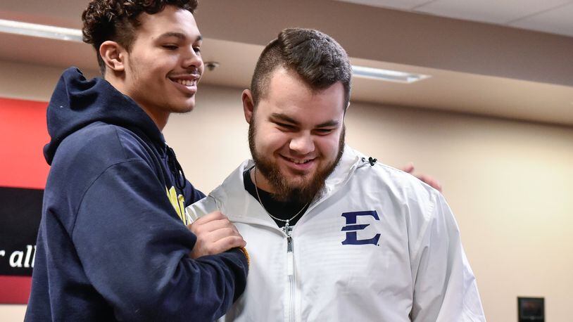 Fairfield seniors Erick All (left) and Jacob Hensley embrace during an early National Signing Day ceremony Wednesday morning at Fairfield High School. All and Hensley signed national letters of intent to attend Michigan and East Tennessee State, respectively. NICK GRAHAM/STAFF
