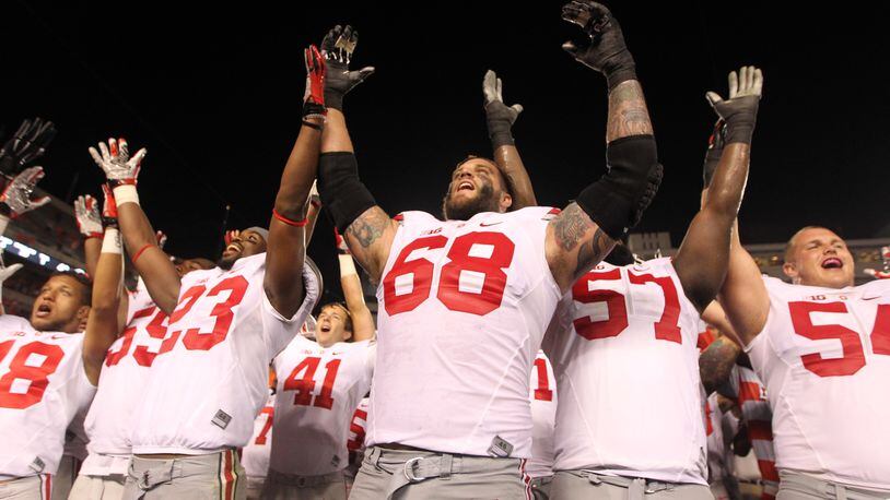 Ohio State’s Taylor Decker, center, and his teammates sing the fight song after a victory against Virginia Tech on Monday, Sept. 7, 2015, at Lane Stadium in Blacksburg, Va. David Jablonski/Staff