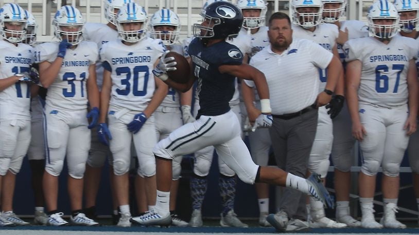 Fairmont's Kamron Payne runs down the side line as carries back the opening kick off for a touchdown in the opening seconds of Friday's game against Springboro. BILL LACKEY/STAFF
