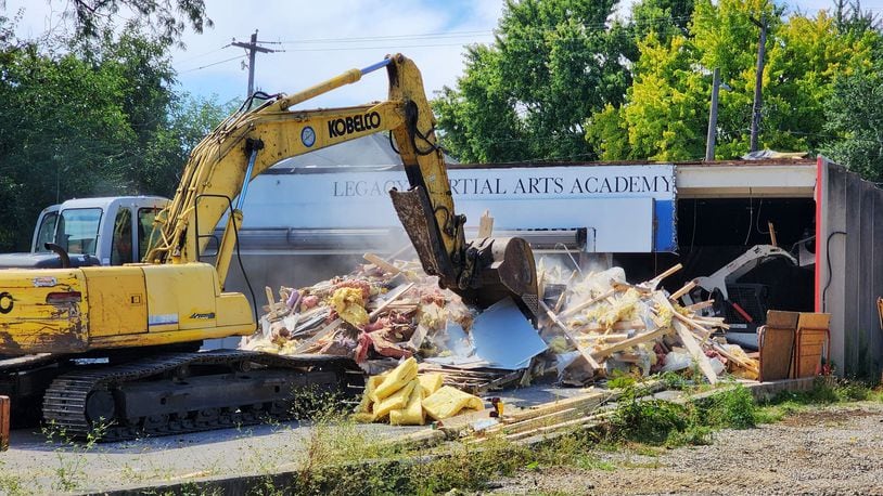 The former Legacy Martial Arts Academy on Main Street began to be razed in Hamilton on Tuesday, making way for a new 23,245-square-foot standalone parking. The 52-space lot, which will include two EV charging stations, will be adjacent to the planned Agave & Rye restaurant. There will be some type of parking enforcement of the lot ― which could be with signs and traffic enforcement monitoring, meters, or a parking kiosk ― and limits wouldn’t be longer than a few hours, city officials said. The Agave & Rye project is expected to begin once the parking lot construction is complete. NICK GRAHAM/STAFF