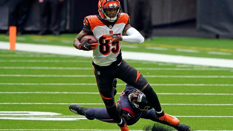 Cincinnati Bengals wide receiver Tee Higgins (85) catches a pass as Houston Texans inside linebacker Zach Cunningham reaches to tackle him during the first half of an NFL football game Sunday, Dec. 27, 2020, in Houston. (AP Photo/Eric Christian Smith)