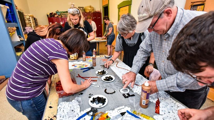 FLE: Art Central Foundation board members and instructors work on a mosaic mural July 26 in Middletown that features the Art Central Foundation logo. NICK GRAHAM/FILE