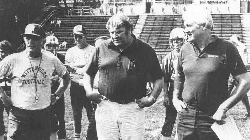 Wittenberg head coach Dave Maurer, left, and CBS announcers John Madden and Pat Summerall talk during practice the week of Wittenberg’s nationally-televised game against Baldwin-Wallace in Springfield in 1982. File photo