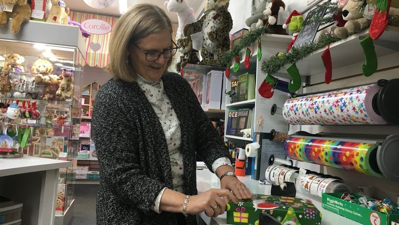 Cathy Tapogna, owner of Blue Turtle Toys, wraps a present. One of the most popular items in the store are the Charlie Bears. STAFF PHOTO / HOLLY SHIVELY