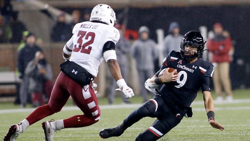 CINCINNATI, OHIO - NOVEMBER 23: Desmond Ridder #9 of the Cincinnati Bearcats avoids a tackle from Benny Walls #32 of the Temple Owls during the second quarter at Nippert Stadium on November 23, 2019 in Cincinnati, Ohio. (Photo by Justin Casterline/Getty Images)