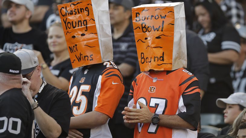 Cincinnati Bengals fans wears paper bags on their heads during the second half of an NFL football game against the Oakland Raiders in Oakland, Calif., Sunday, Nov. 17, 2019. (AP Photo/Ben Margot)
