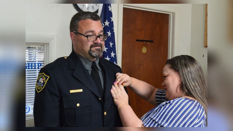 New Oxford Township Police Chief Patrick Piccioni has his badge pinned on by his wife, Jennifer, following his oath of office for the position. CONTRIBUTED/BOB RATTERMAN