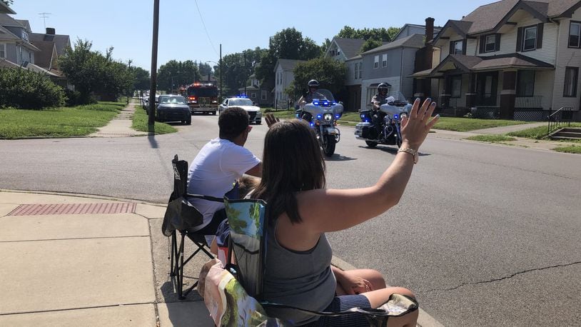 Josh Crouch, Jessica Taylor and their son, Tyler, 7, watch the Perseverance through the Pandemic Driving Parade Saturday morning on Central Avenue. RICK McCRABB/STAFF
