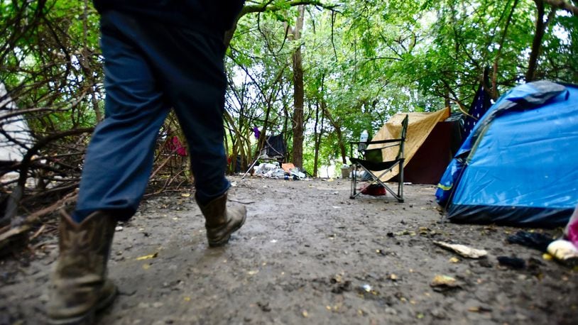 A man walks through a homeless camp that has since been cleared out in Hamilton. There are several homeless initiates geared towards helping homeless in Butler County. NICK GRAHAM / STAFF