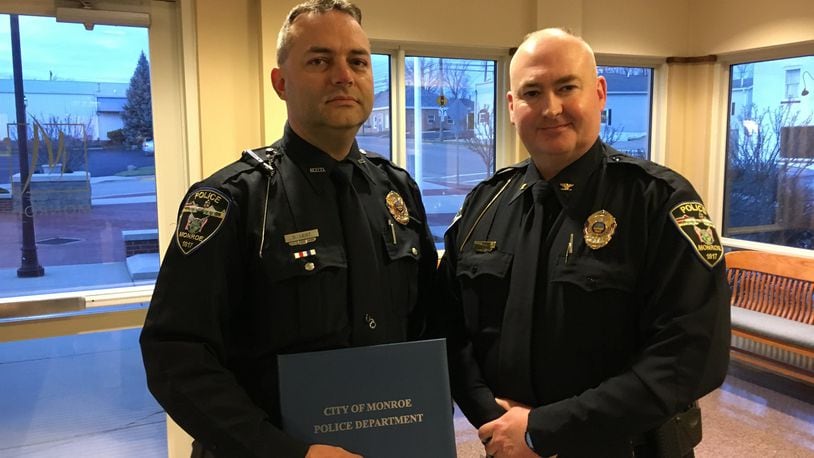 Monroe police Officer Doug Leist, left, received the Medal of Merit from police Chief Bob Buchanan during a Monroe City Council meeting. Leist was recognized for his actions following a fatal shooting at a Monroe residence last August. ED RICHTER/STAFF