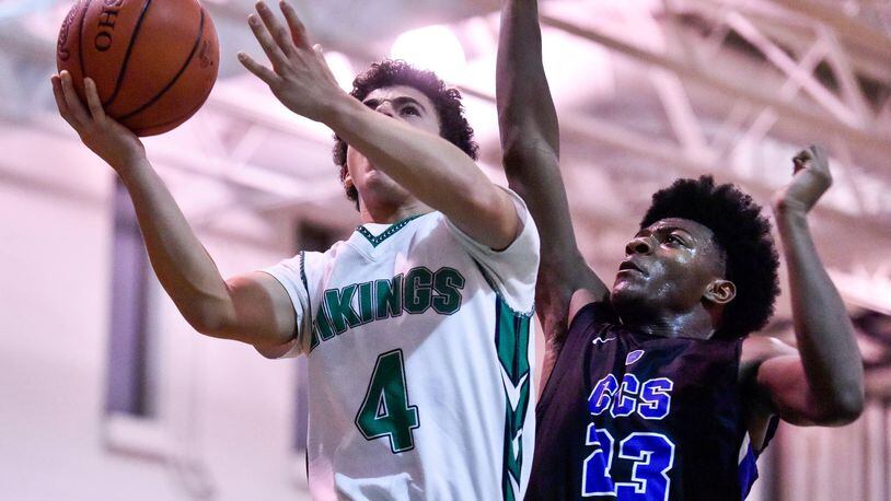 New Miami’s Deanza Duncan goes to the hoop while being defended by Cincinnati Christian’s Cameron Rogers during Friday night’s game at New Miami. CCS won 70-52. NICK GRAHAM/STAFF
