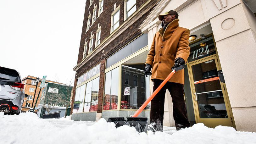Sterling Jackson shovels snow in front of businesses along Central Avenue Friday morning, Feb. 1, 2019 in Middletown. NICK GRAHAM/STAFF