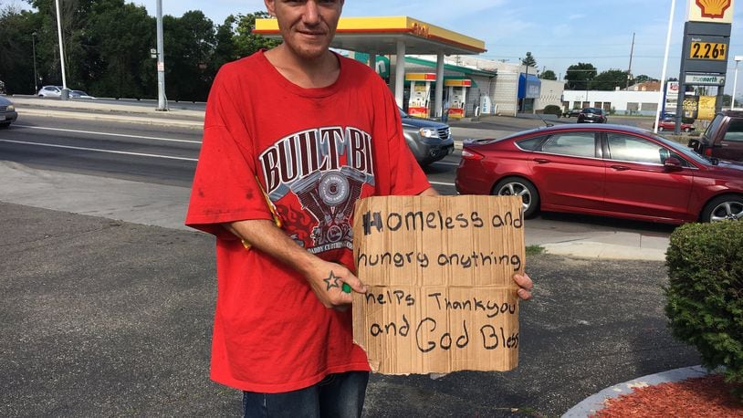 Charles Young holds a sign near the intersection of U.S. 35 and Smithville Road. “I’ve been looking for a job. It’s just been rough. I don’t want to do this. I want to get off the street,” he said.