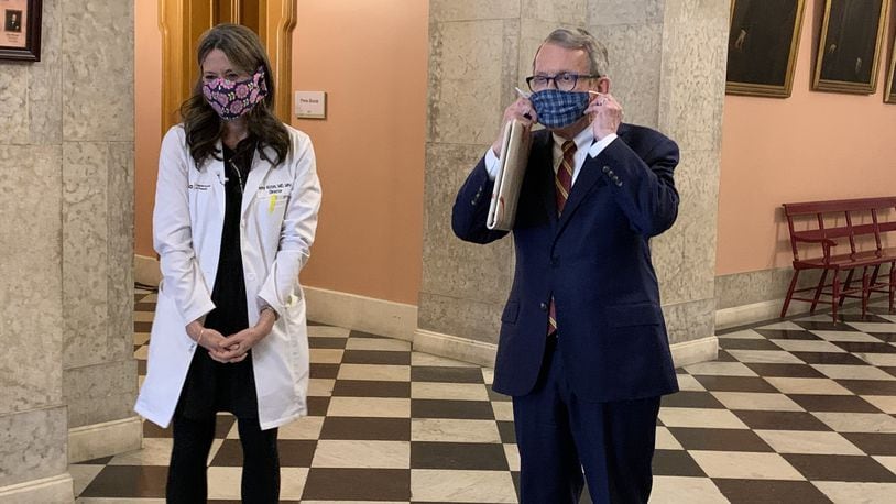 Ohio Gov. Mike DeWine and Ohio Health Department Director Dr. Amy Acton show off their protective masks at the statehouse on Monday. Photo by Laura A Bischoff..Columbus bureau
