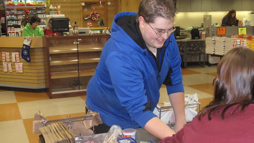 In this recent photo, Brady Long, left, bags groceries at Buehler's Fresh Foods at Forest Meadows in Medina, Ohio. Long, a 23-year-old University of Akron accounting student, has been named the nation's top grocery bagger after claiming the Ohio title two years in a row. He competed against nearly two dozen others in the National Grocers Association's Best Bagger championship in Las Vegas. (Bob Finnan/Medina County Gazette via AP)