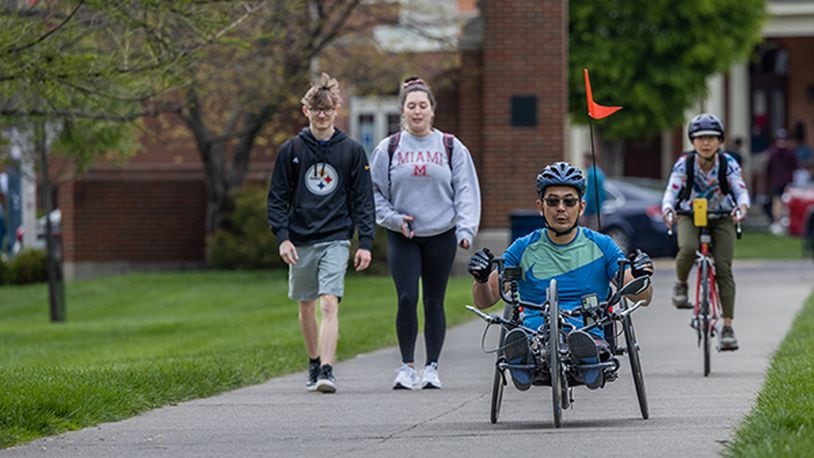 Miami University Associate Professor of Biology Yoshi Tomoyasu trains on his handcycle bike on the Miami University campus. He rides with his wife, Chie. CONTRIBUTE