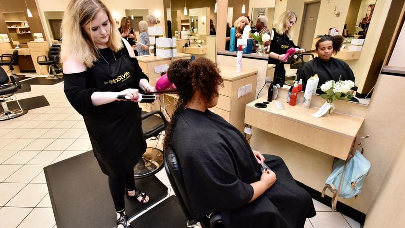 Kathlene Riggs styles Yazmyne Richardson’s hair at Salon InStyle inside JCPenney at Bridgewater Falls. The revamped salon opened Friday, June 15, 2018, at the store. The JCPenney store in Fairfield Twp. is one of 100 locations nationwide to receive the updated salon concept this year. NICK GRAHAM/STAFF