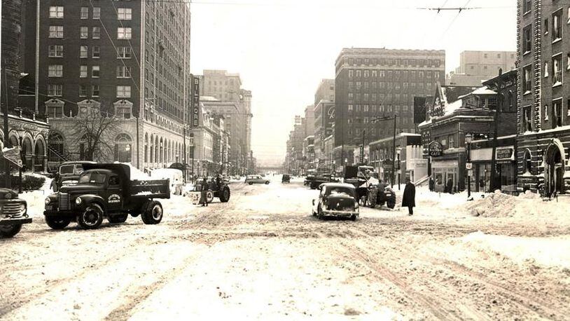 Vehicles and pedestrians attempt to navigate Main St. in downtown Dayton after nearly a foot of snow fell across the region after Thanksgiving Day in 1950