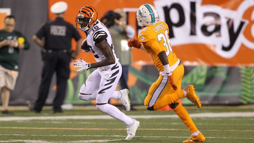 A.J. Green of the Cincinnati Bengals attempts to run the ball past Tony Lippett of the Miami Dolphins during the 2016 season at Cincinnati. (Photo by John Grieshop/Getty Images)