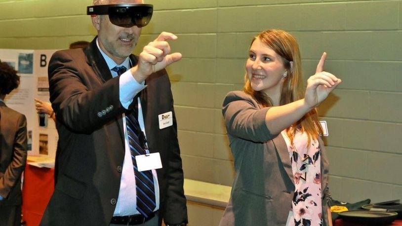 Butler Tech Superintendent Jon Graft gets a demonstration of a new app for learning visors invented by Ross High School students. Among the inventors is sophomore Isabella Saylor, who recently guided Graft through the visor’s “mixed reality” demonstration.