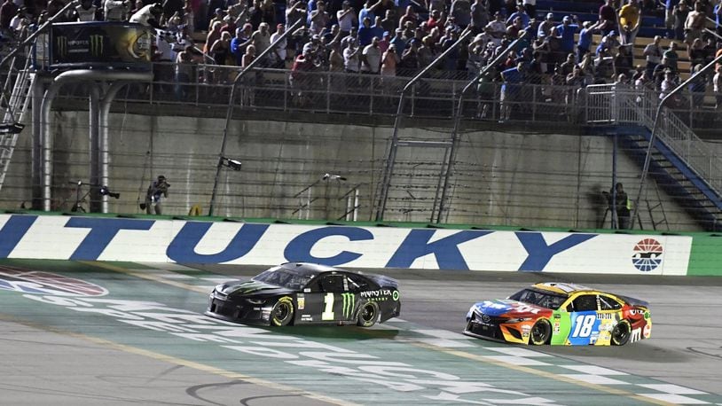 Kurt Busch crosses the finish line ahead of Kyle Busch (18) to win the NASCAR Cup Series auto race at Kentucky Speedway in Sparta, Ky., Saturday, July 13, 2019. (AP Photo/Timothy D. Easley)