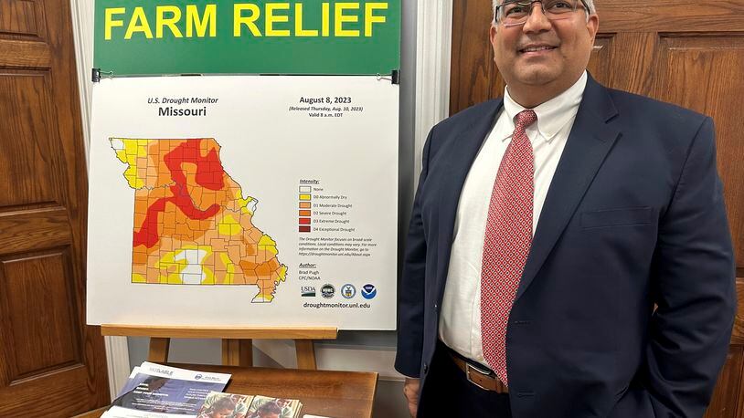 FILE - Missouri Treasurer Vivek Malek stands near a poster promoting drought conditions and state aid programs, Jan. 4, 2024, at his Capitol office in Jefferson City, Mo. Agricultural entities are among several categories of businesses that can receive low-interest loans backed by deposits of state funds made by the treasurer's office. Missouri lawmakers gave final approval Thursday, April 18, to significantly expand a low-interest loan program for farmers and small businesses. (AP Photo/David A. Lieb, File)