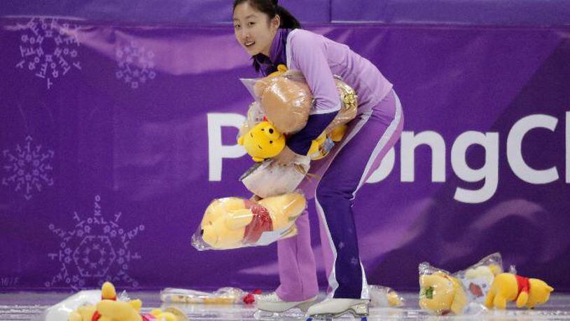A skating girl collects Winnie The Pooh toys off the ice following Yuzuru Hanyu of Japan's performance during the men's short program figure skating in the Gangneung Ice Arena at the 2018 Winter Olympics in Gangneung, South Korea, Friday, Feb. 16, 2018. (AP Photo/Julie Jacobson)
