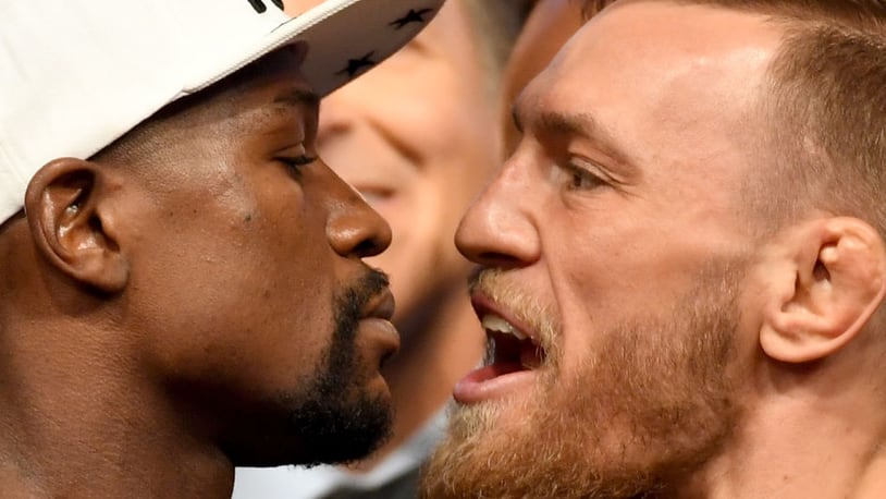 Boxer Floyd Mayweather Jr. (left) and UFC lightweight champion Conor McGregor face off during their official weigh-in at T-Mobile Arena .