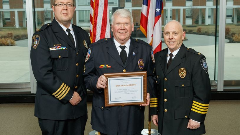 Fairfield police Sgt. Don Garrett, center, receives his certificate from the Certified Law Enforcement Executive program in Columbus. CONTRIBUTED