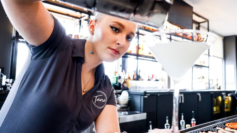 Gracelyn Stitzel prepares a drink at the bar at Tano Bistro Thursday, April 21, 2022 in Hamilton. Tano is one of many restaurants that have limited days open due to staffing issues. NICK GRAHAM/STAFF