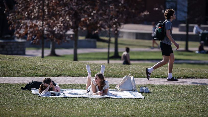 University of Dayton students enjoy the sun Wednesday, March 1, when the temperature in Dayton recorded a daily record high temperature. JIM NOELKER/STAFF