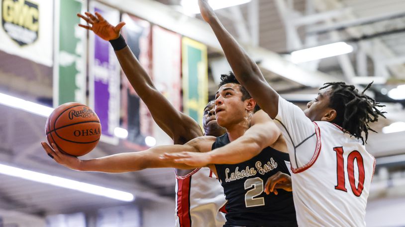 Lakota East's Jadon Coles (2) goes up for a shot defended by Lakota West's Jason Lavender (10) and Christopher Barber during their basketball game Friday, Dec. 17, 2021 at Lakota West High School in West Chester Township. Lakota East won 70-64. NICK GRAHAM / STAFF