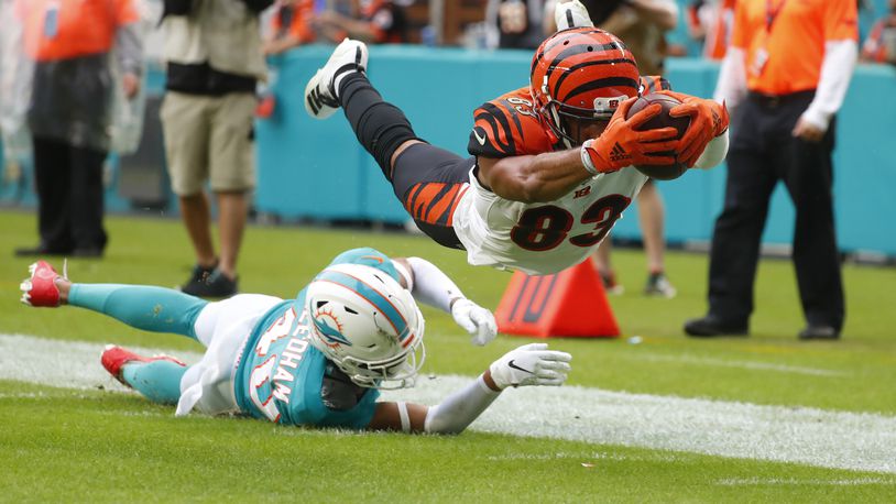 Cincinnati Bengals wide receiver Tyler Boyd (83) stretched for a touchdown as Miami Dolphins defensive back Nik Needham (40) is unable to defend, during the second half at an NFL football game, Sunday, Dec. 22, 2019, in Miami Gardens, Fla. (AP Photo/Wilfredo Lee)