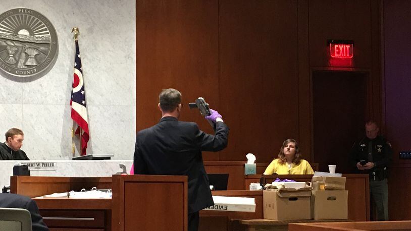 Assistant Warren County Prosecutor Travis Vieux holds up the AK-47 pistol allegedly used in a Christmas Day 2016 murder, while the victim’s cousin testified on Wednesday in Warren County Common Pleas Court.Staff photo by Lawrence Budd