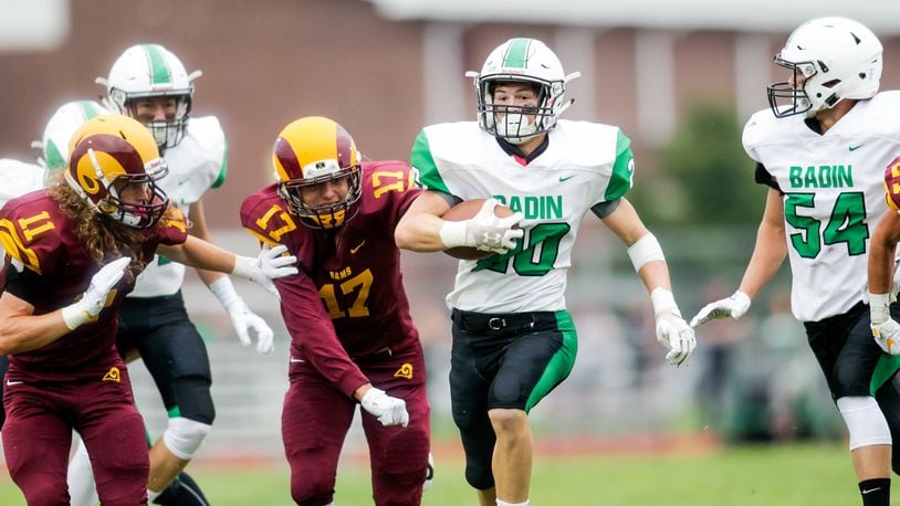 Badin’s Alex DeLong (20) is escorted by teammate Evan Schlensker (54) as Jordan Hodge (11) and Sean Lange (17) of Ross are in pursuit during an Aug. 24 game at Robinson Field in Ross Township. Badin won 41-20. NICK GRAHAM/STAFF