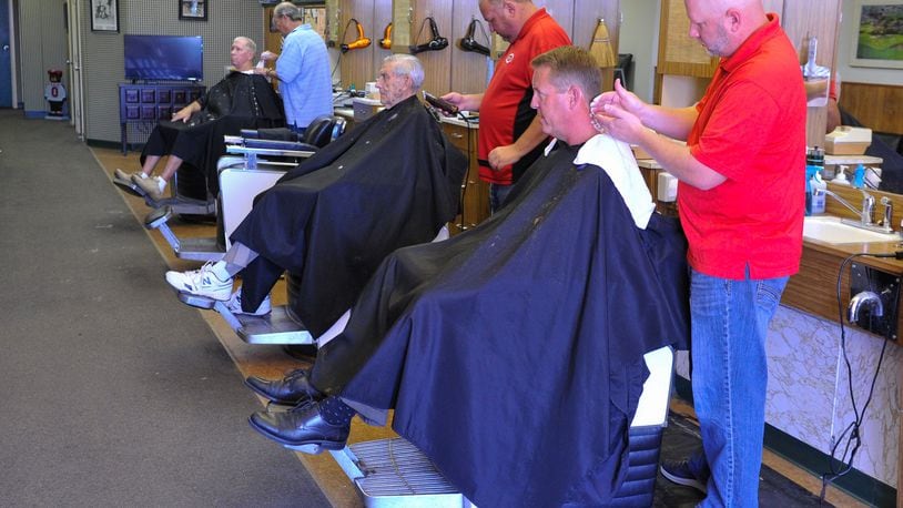 Ryan Haynes, right, owner of the Hamilton West Barber Shop, cuts Mike Schutter’s hair Tuesday, Aug. 28 in the The Hamilton West Shopping Center in Hamilton. The barber shop has been in the same shopping center for 50 years. After a remodeling, they will move into a former Chevron station nearby. NICK GRAHAM/STAFF