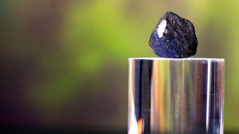 A piece of stony-iron meteorite sits on a display during a press conference, Friday, Jan. 19, 2018, at the Longway Planetarium in Flint, Mich. Longway Planetarium astronomers have located three meteorites, after a meteor broke apart about 20 miles over Earth Tuesday. Most of the meteoriteâs fragments landed in Hamburg Township, Mich. The meteor will be sent to NASA for analysis. (Bronte Wittpenn/The Flint Journal-MLive.com via AP)