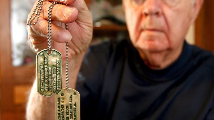 World War II United States Army veteran Bill Wilch with the dog tags he wore when he stormed the beaches of Normandy with the 29th Ranger Battalion during the D-Day invasion in 1944. STAFF FILE/2014
