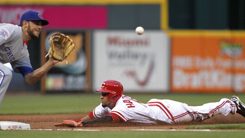 The Reds’ Billy Hamilton steals third base in front of a throw to Cubs third baseman Kris Bryant, left, in the third inning on Friday, April 24, 2015, at Great American Ball Park in Cincinnati. David Jablonski/Staff