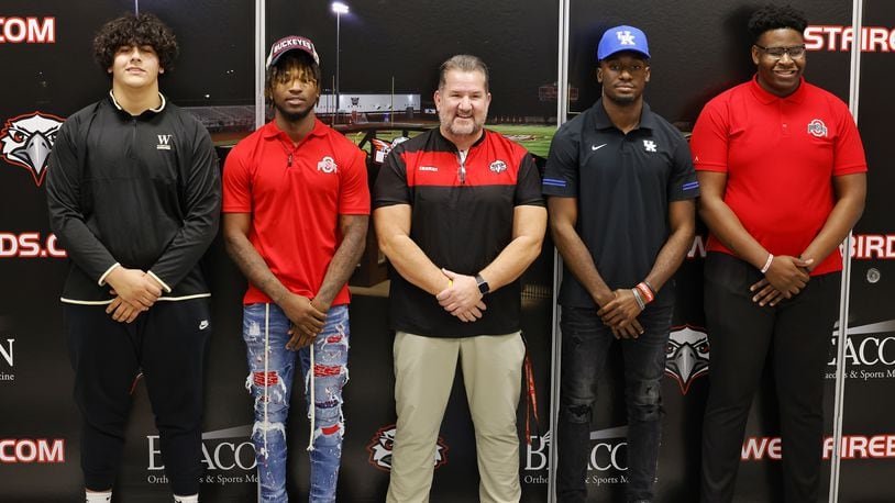 Left to right: Latham McComis, Jyaire Brown, Lakota West head football coach Tom Bolden, Alex Afari and Tegra Tshabola stand for photos during a national letter of intent college football signing ceremony Wednesday, Dec. 15, 2021 at Lakota West High School. Latham McComis is signing with Wofford College, Jyaire Brown is signing with The Ohio State University, Alex Afari is signing with University of Kentucky and Tegra Tshaboa is signing with The Ohio State University. NICK GRAHAM / STAFF