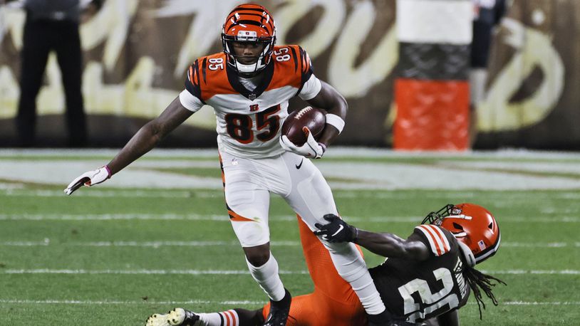 Cincinnati Bengals wide receiver Tee Higgins (85) breaks a tackle from Cleveland Browns cornerback Tavierre Thomas (20) during the second half of an NFL football game Thursday, Sept. 17, 2020, in Cleveland. (AP Photo/Ron Schwane)