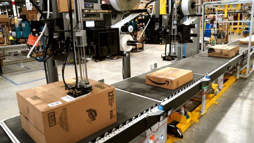A machine applies shipping lables to packed orders at an  Amazon fulfillment center.