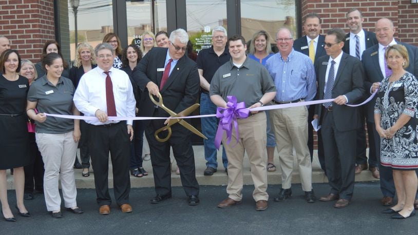 First Merchants Bank officials and employees along with city officials and representatives of the Oxford Chamber of Commerce gathered May 11 for the formal ribbon-cutting at the bank s new location in Stewart Square. Performing the ceremonial cutting is Banking Center Manager Scott Anderson. CONTRIBUTED/BOB RATTERMAN