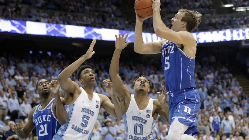 North Carolina’s Tony Bradley (5) and Nate Britt (0) defend against Duke’s Luke Kennard during the second half of an NCAA college basketball game in Chapel Hill, N.C., Saturday, March 4, 2017. North Carolina won 90-83. (AP Photo/Gerry Broome)