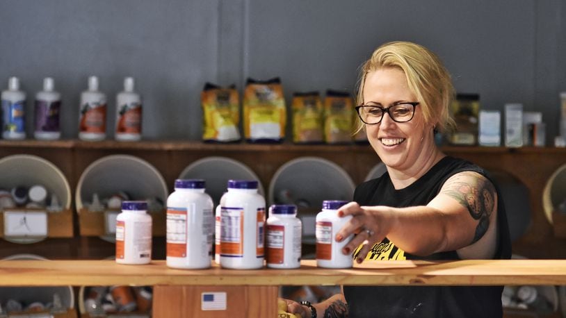 Owner Jamie Benge places product on shelves ahead of the ribbon cutting for Soulshine Wellness on Main Thursday, Sept. 3, 2020 at 508 Main Street in Hamilton. NICK GRAHAM / STAFF